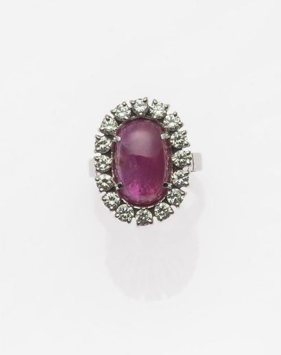 null RING in 750MM white gold centered of an oval cabochon ruby in a row of diamonds,...