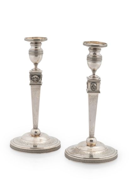null Pair of silver torches and their wicks

Empire style, the base bordered with...