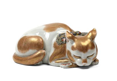 null JAPON, figurine représentant un chat couché en porcelaine, le pelage décoré...