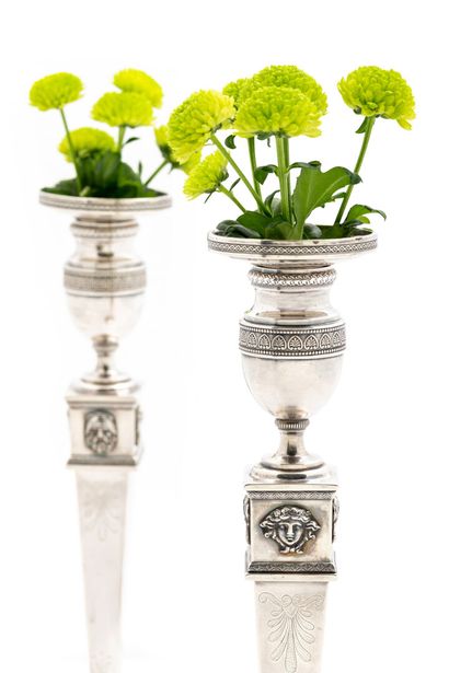 null Pair of silver torches and their wicks

Empire style, the base bordered with...