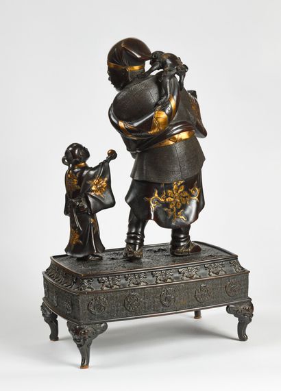 null A JAPANese bronze group with a brown patina and a gold niello representing a...