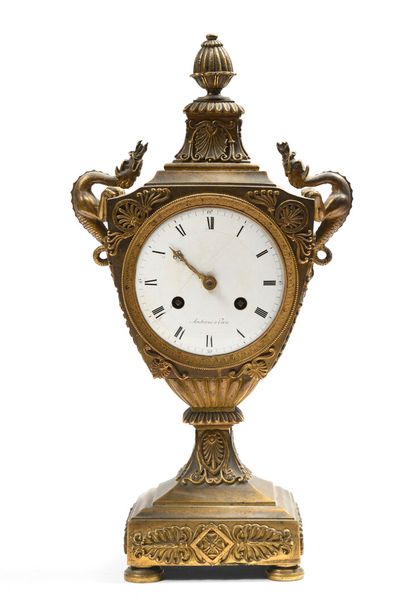 null Chased and gilt bronze clock in the form of an escutcheon topped by a godron...