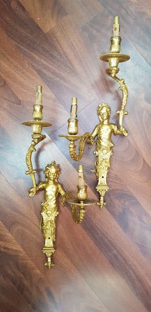 null A pair of Regency style two-light gilt bronze sconces decorated with sheathed...