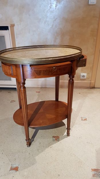 null Oval shaped coffee table inlaid with scrolls on the belt, one drawer and two...