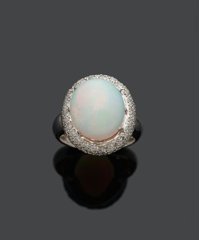 null Bague en or gris 18K 750‰, sertie en son centre d'une opale de forme ovale taillée...