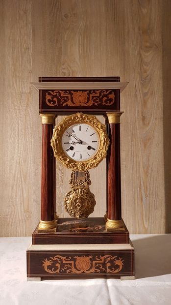 null Portico clock in marquetry of light wood foliage on mahogany background.
Dial...