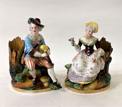 null Pair of polychrome porcelain groups featuring a young girl with a rose and a...