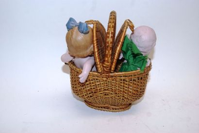 null Basket containing two small bisque dolls, moulded hairstyles and painted ey...
