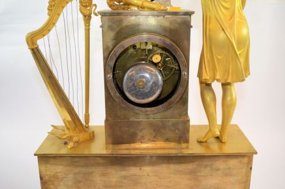 PENDULE EMPIRE Pendule Empire en bronze doré, avec personnage et attribut de musique...
