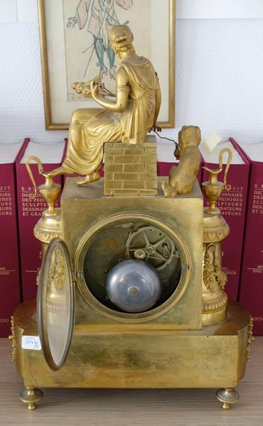 null Pendule en bronze doré, à décor d'une fileuse assise sur une fontaine flanquée...