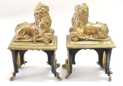 null Paire de chenets en bronze ciselé et doré figurant un lion couché sur une base...
