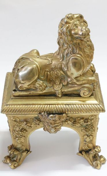 null Paire de chenets en bronze ciselé et doré figurant un lion couché sur une base...