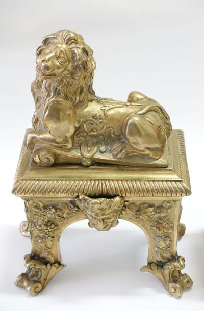 null Paire de chenets en bronze ciselé et doré figurant un lion couché sur une base...