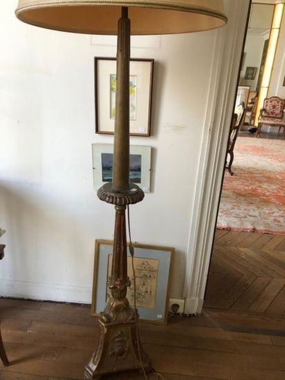 null Gilded wooden candle stick, the fluted shaft, resting on a triangular base decorated...