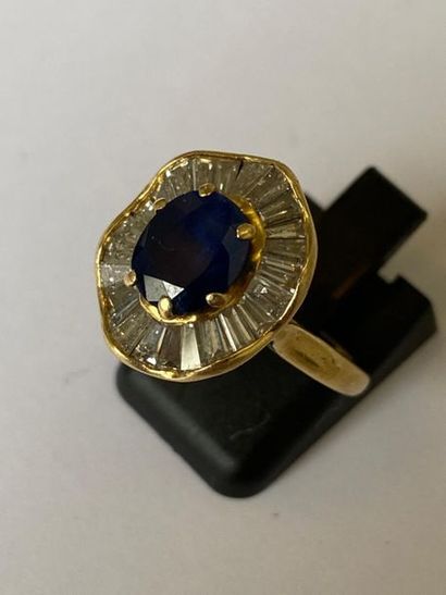 null Ring in 750 thousandths yellow gold set with an oval sapphire in a skirt setting...