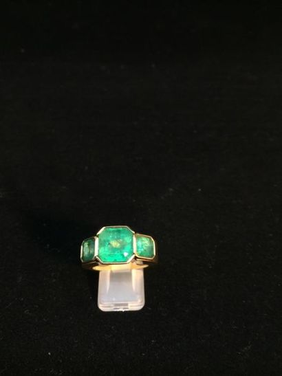 null 750-thousandths yellow gold ring set with three rectangular emeralds with cut-off...
