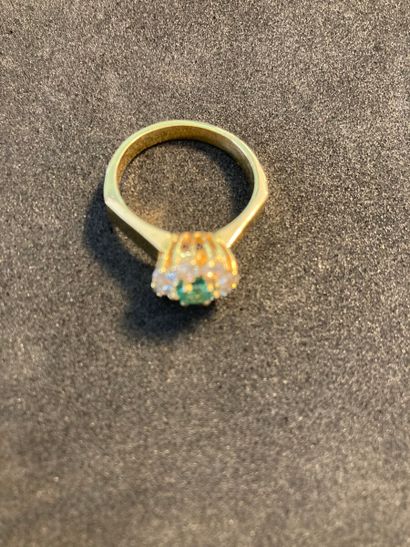 null Ring in yellow gold 750 thousandths decorated with an emerald in a circle of...