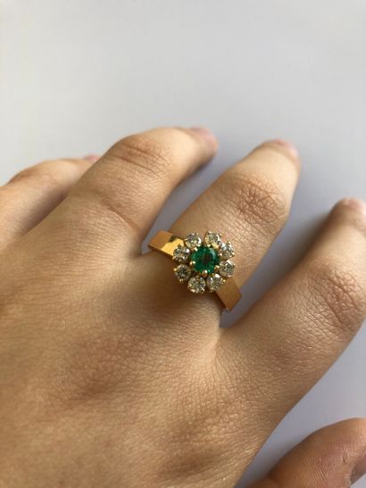 null Bague en or jaune 750 millièmes ornée d'une émeraude dans un entourage de huit...