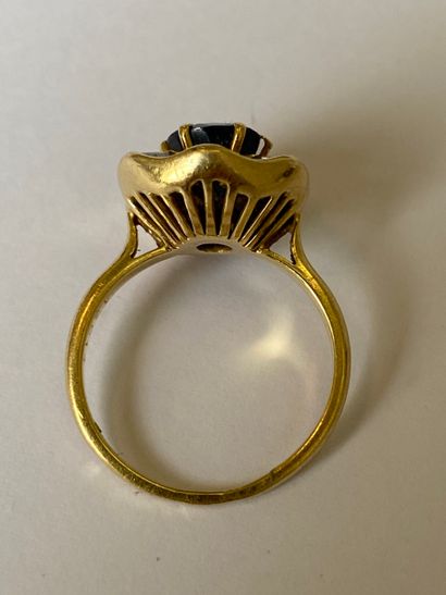 null Bague en or jaune 750 millièmes ornée d'un saphir ovale dans un entourage formant...