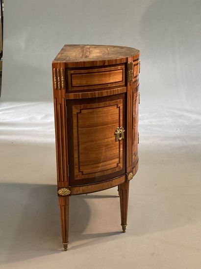 null A rosewood and amaranth half-moon chest of drawers, opening to three drawers...