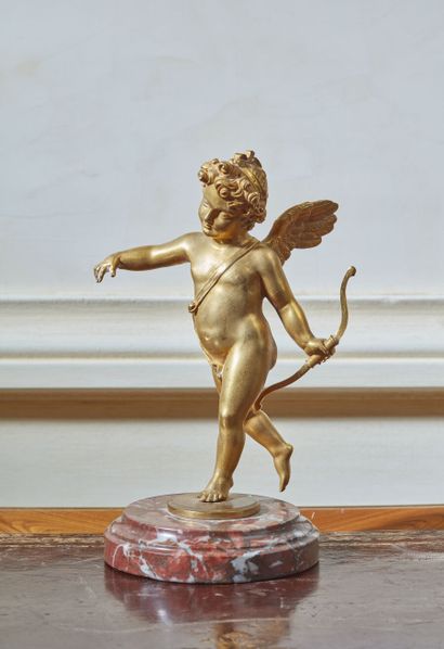 null Sujet en bronze doré figurant un Amour ailé tenant un arc, sur une base circulaire...