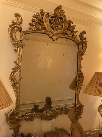 null Miroir dans un encadrement en bois sculpté et doré à décor ajouré de rinceaux...