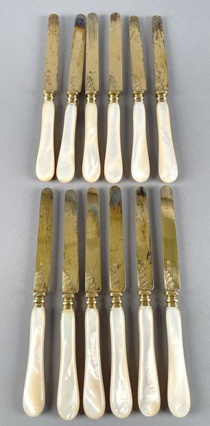 null Twelve fruit knives, the blades in 950 thousandths vermeil, with leafy attachments,...