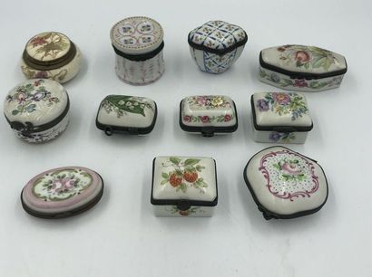 Onze boites à pilules en porcelaine à décor floral polychrome , diverses formes,...