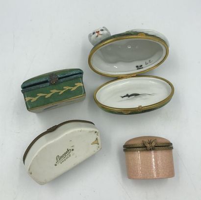 Quatre boites à pilules en porcelaine et monture métal dont une à décor d'un chat...