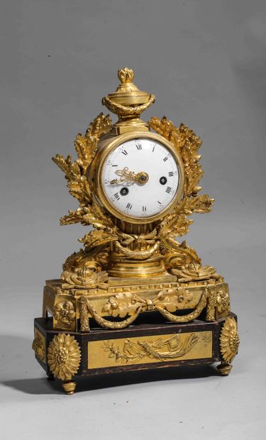 null 
Chased and gilt bronze clock surmounted by an urn; white enamel dial surrounded...