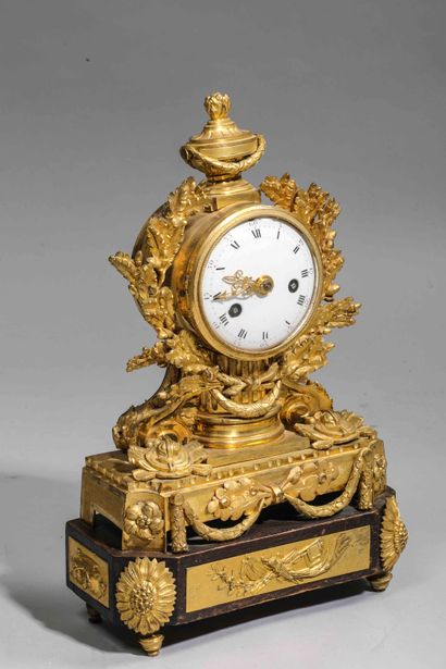 null 
Chased and gilt bronze clock surmounted by an urn; white enamel dial surrounded...
