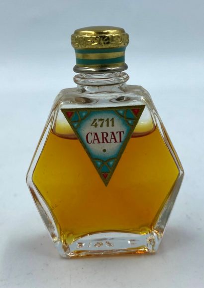 4711 4711 " Carat " 

Glass bottle, sculptural shape, triangular label, titled. Golden...