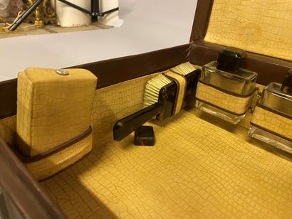 Nécessaire de toilette de voyage dans une malette en cuir couleur lie-de-vin complète...