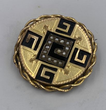 Broche de forme ronde en  métal, onyx noir et demi perle à motifs de G