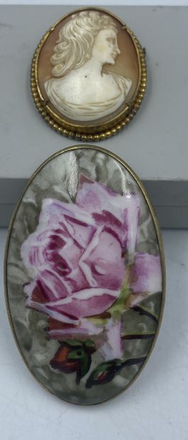 Lot comprenant une broche camée coquille à profil de femme monture en métal doré à frise de perle, une broche à plaque en porcelaine peint à décor de rose monture en métal.