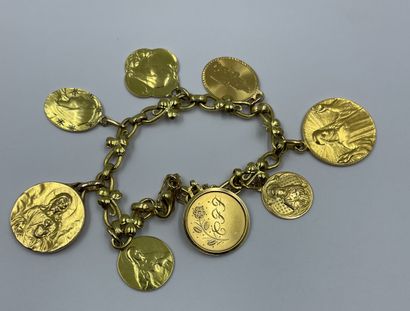 BRACELET en or jaune 18K (750 millièmes) orné de médailles en pendeloques gravées de saintes ou fleurs