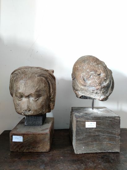 Deux fragments de tête de femme en pierre reposant sur un socle Deux fragments de...