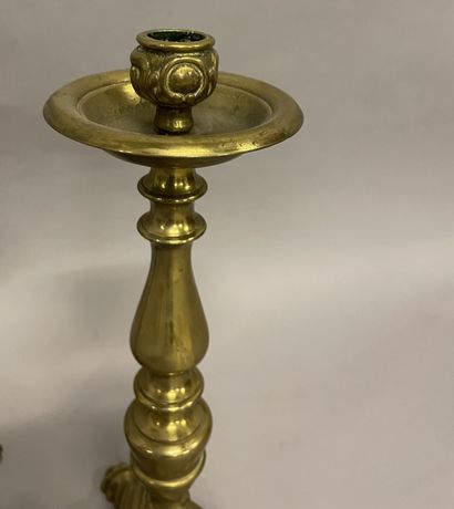 DEUX BOUGEOIRS en laiton style Régence TWO brass CANDLES resting on a triangular...