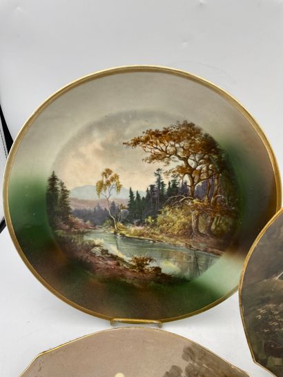ASSIETTES TWO hollow porcelain plates decorated with a lake landscape in the center...