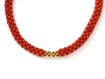 Collier composé d'une tresse de petites perles de corail, centré d'un décor en perles d'or 750 millièmes. Il est agrémenté d'un fermoir mousqueton en or 750 millièmes. (légers fêles)