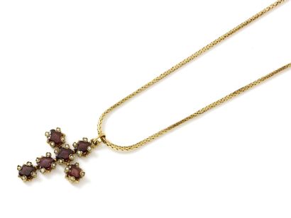 Pendentif en or 750 millièmes, retenant une croix habillée de grenats facettés encadrés de demi-perles. Il est retenu par une chaîne en or 750 millièmes, maille souple, agrémentée d'un fermoir à cliquet ciselé. Travail français de la fin du XIX