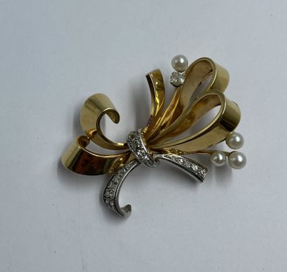 BROCHE en or jaune et blanc motif de noeud stylisé serti de brillants et demi perle...