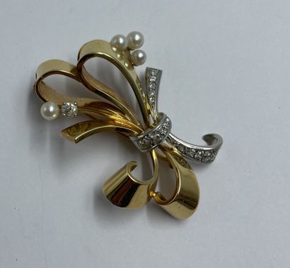 BROCHE en or jaune et blanc motif de noeud stylisé serti de brillants et demi perle...