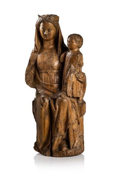 Vierge à l’Enfant en noyer sculpté en ronde-bosse. Assise sur un banc trône, Marie porte l’Enfant debout sur son genou gauche, la tête coiffée d’une couronne posée sur un voile mi-long ; elle est vêtue d’une robe à l’encolure ronde ceint