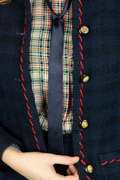 null CHANEL 
Tailleur en tweed de laine bleu marine et surpiqûres rouges, la veste...