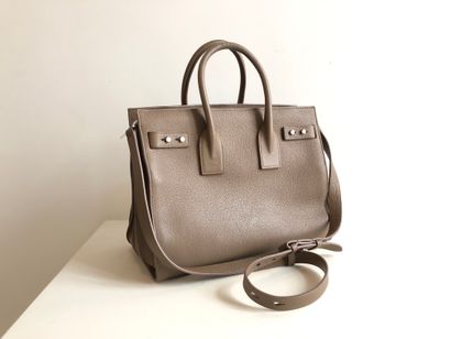 null 
HOLY LAWRENCE 


Bag model 
Day Bag in taupe grained leather. The interior...