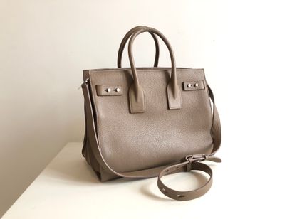 null 
SAINT LAURENT 


Sac modèle 
Sac de Jour en cuir grainé taupe. L’intérieur...