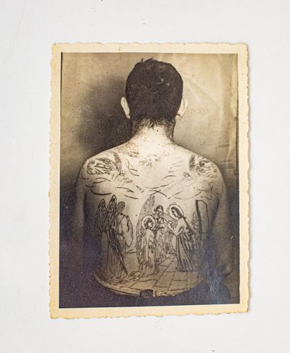 null Tatoué. Une photographie d’un dos d’homme recouvert de tatouages, marquée au...