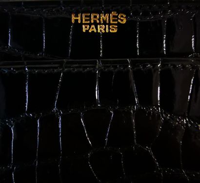 HERMES Sac à rabat en crocodile noir et garniture en métal doré. L'intérieur compartimenté...