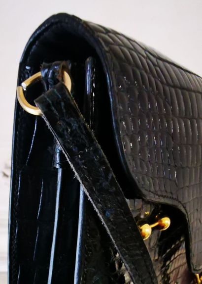 HERMES Sac à rabat en crocodile noir et garniture en métal doré. L'intérieur compartimenté...